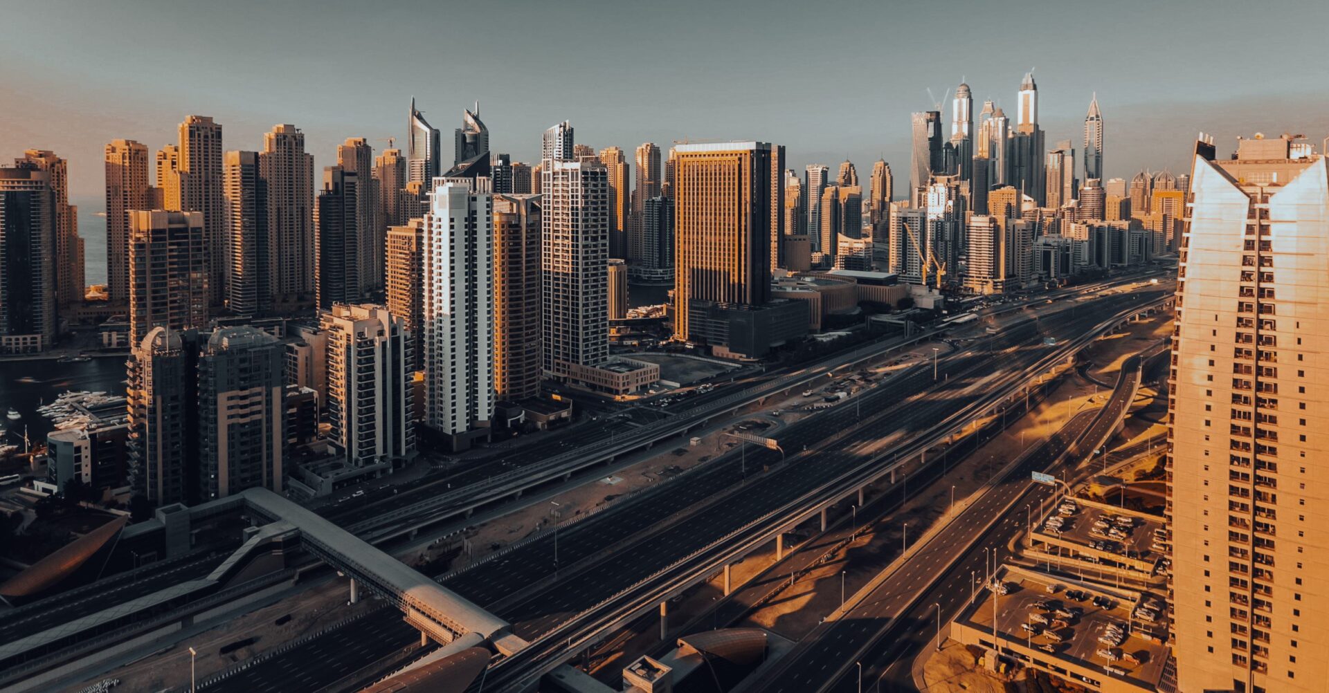 Aerial view of Jumeirah Lakes Towers and Sheikh Zayed Road at golden hour in Dubai