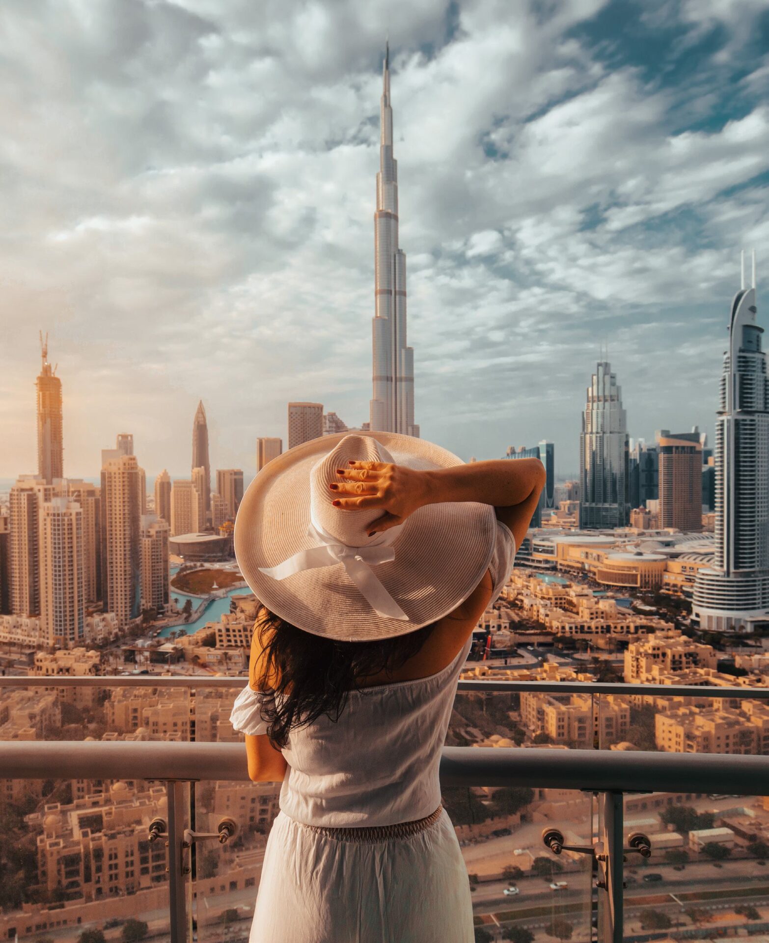 Woman enjoying panoramic view of Burj Khalifa and Dubai skyline from luxury balcony
